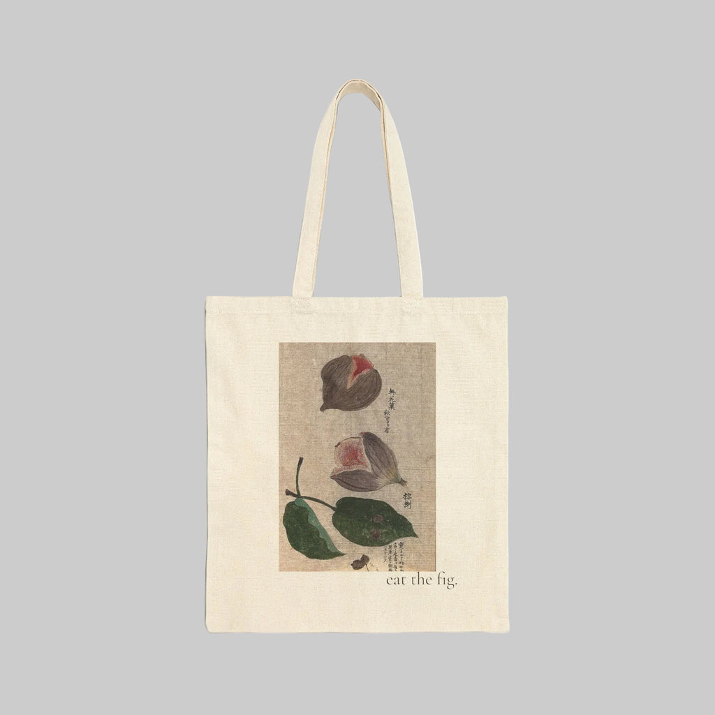 A cream-colored canvas tote bag with two shoulder straps, featuring a vintage-style botanical illustration of figs on the front. The illustration includes green leaves and brown figs on a textured beige background, with the text 'eat the fig' printed below.
